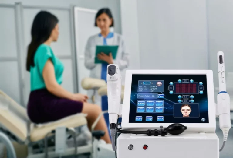 Female patient consulting a gynecologist about HIFU vaginal rejuvenation, with the specialized HIFU device and specialized vaginal attachment prominently displayed in the foreground.